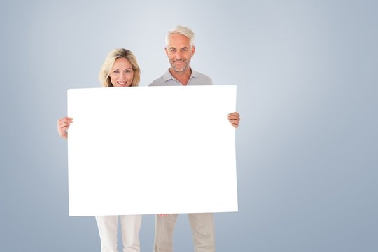 Composite Image Of Happy Couple Holding Large Poster