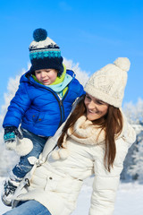 Fototapeta na wymiar Happy family on the walk in sunny, snowy day - winter holidays