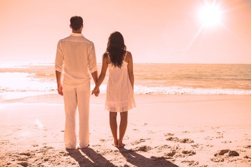 Attractive couple holding hands and watching the waves