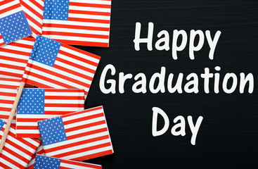 Fototapeta na wymiar Happy Graduation Day on a blackboard with USA flags