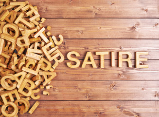 Word satire made with wooden letters
