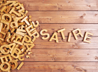 Word satire made with wooden letters