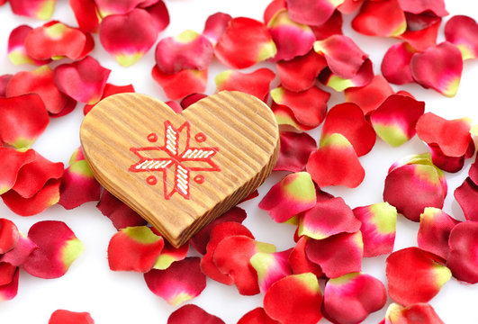 Wooden Heart on a background of red petals