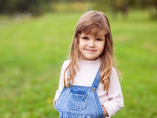 Cute little girl on the meadow in summer day