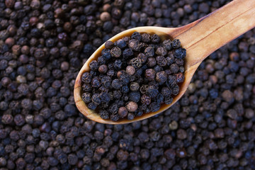 black pepper in wooden spoon