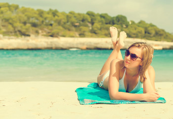 Young woman sunbathing on tropical beach.