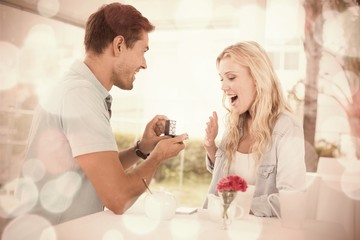 Obraz na płótnie Canvas Man proposing marriage to his shocked blonde girlfriend