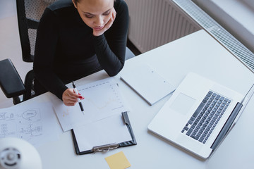 Woman analyzing chart of work progress and planning