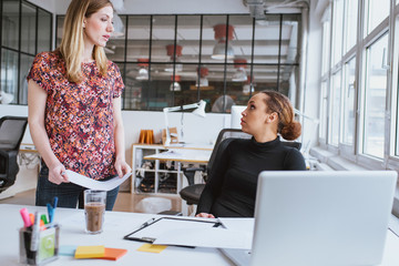 Woman discussing work with colleague at office