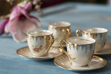 Vintage tea cups with saucers on old wooden table.