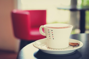 Coffee cup on the table in coffee shop - vintage style effect