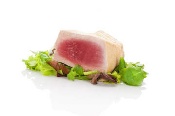 Delicious tuna steak on green salad.