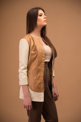 Portrait of a fashion woman looking away over brown background