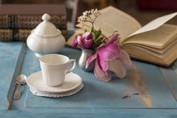 A pretty coffee cup and sugar bowl on old wooden table