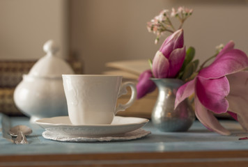 A tea cup with sugar bowl on old wooden table.