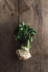 Celeriac with leaves, on wooden table