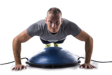 Attractive athletic young man working out with balance board