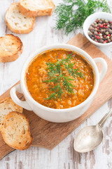 tomato soup with rice and vegetables in white saucepan and bread