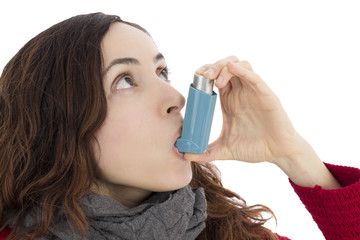 Woman with asthma using inhaler