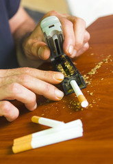 Man rolling cigarettes using fresh tobacco