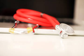 Stethoskop liegt neben Laptop