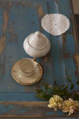 A pretty coffee cup and a sugar bowl on old wooden table