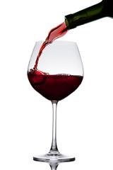 Red wine poured in a glass isolated on white