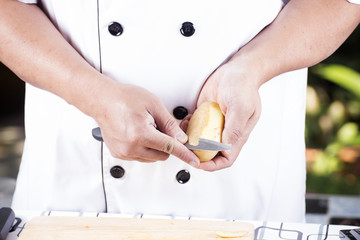 Chef peeling Potato with knife