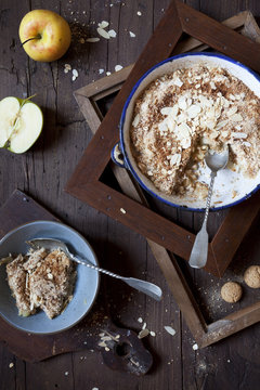 apple crumble with almonds on rustic table with wood frames