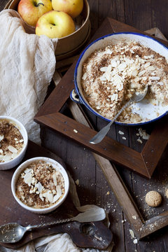 apple crumble with almonds on rustic table with wood frames