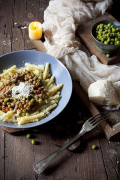 pasta with tomato and peas sauce on plate with parmesan