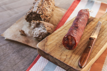 Spanish sausage with bread over a wooden table