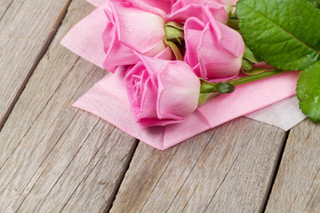 Fototapeta na wymiar Garden pink roses bouquet over wooden table