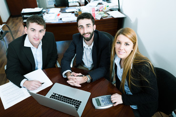 Young business people discuss the new project at office, looking