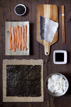 overhead shot of ingredients for preparing sushi on wooden table