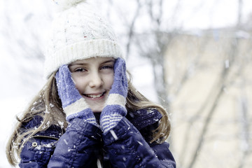 Happy little girl spending a time outdoor in winter