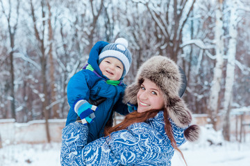 Fototapeta na wymiar Happy mother and baby playing on snow