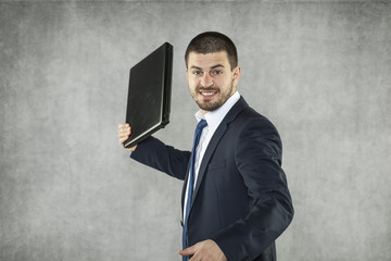 angry businessman ready to destroy a laptop