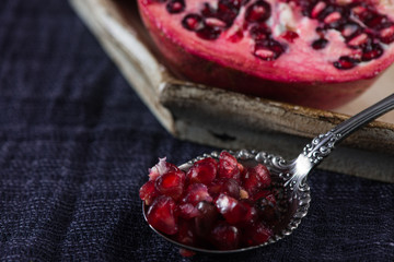 Fresh cut pomegranate fruit with seeds on spoon