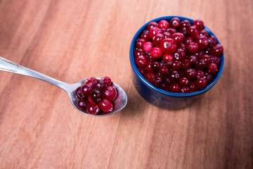 cranberries in a spoon with blue dishes in the background