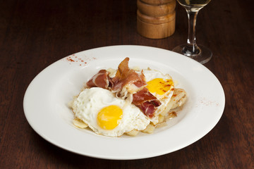 Eggs, potatoes and serrano ham. Huevos rotos.