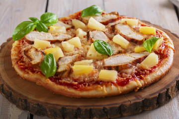 Pizza with cheese and pineapple chicken on board