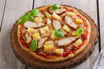 Pizza with cheese and pineapple chicken on board
