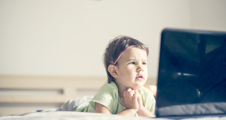 little girl watching cartoons at laptop