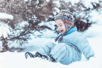 Fototapeta na wymiar little happy child sitting in the snow