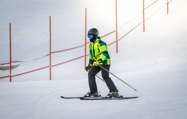 man in green suit skiing down the hill