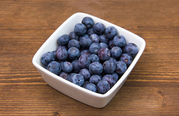 Blueberries on square bowl on wooden table