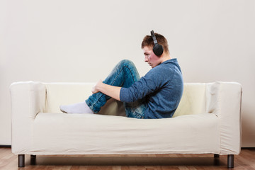 Fototapeta premium Young man with headphones sitting on couch