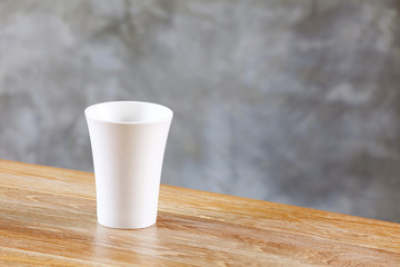 white glass on table in front of wall