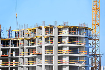 Crane and building construction site against blue sky